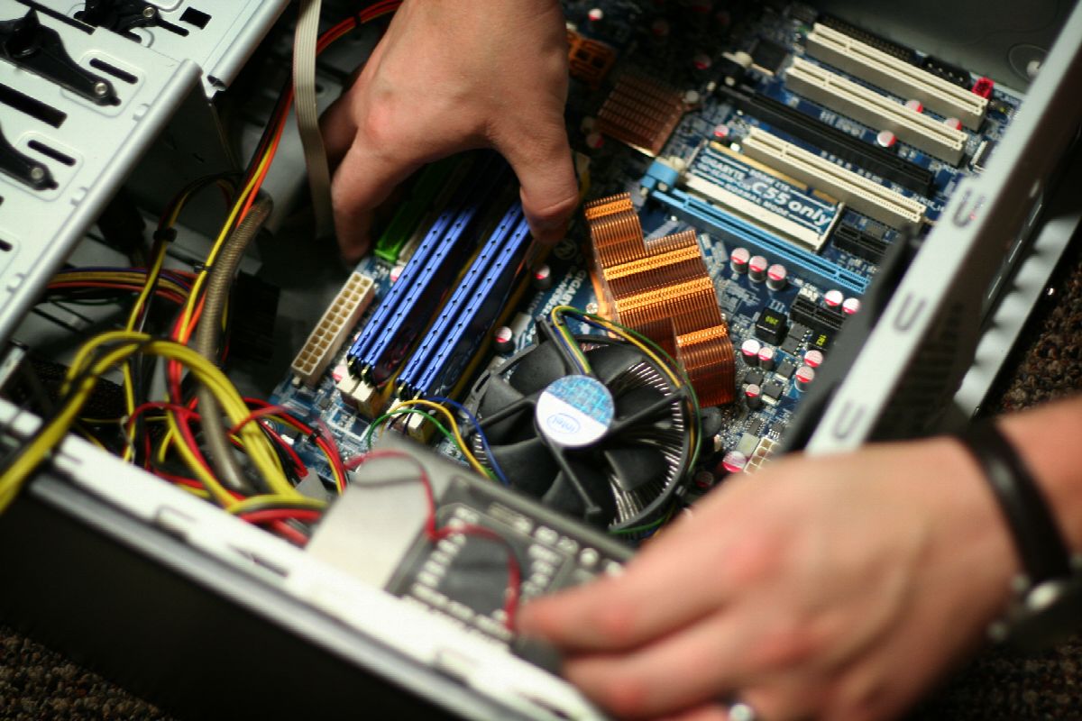 Hands working inside an open desktop computer